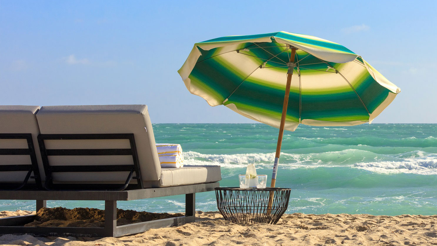 two beach chairs and umbrella on the beach