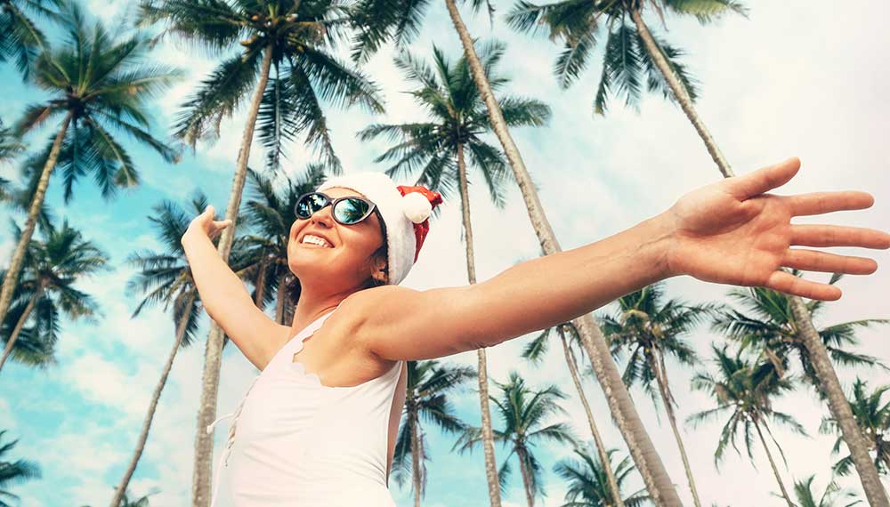 woman in santa hat under palm trees